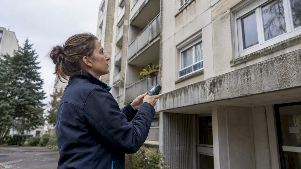 Diagnostiqueuse en train d'inspecter un immeuble collectif